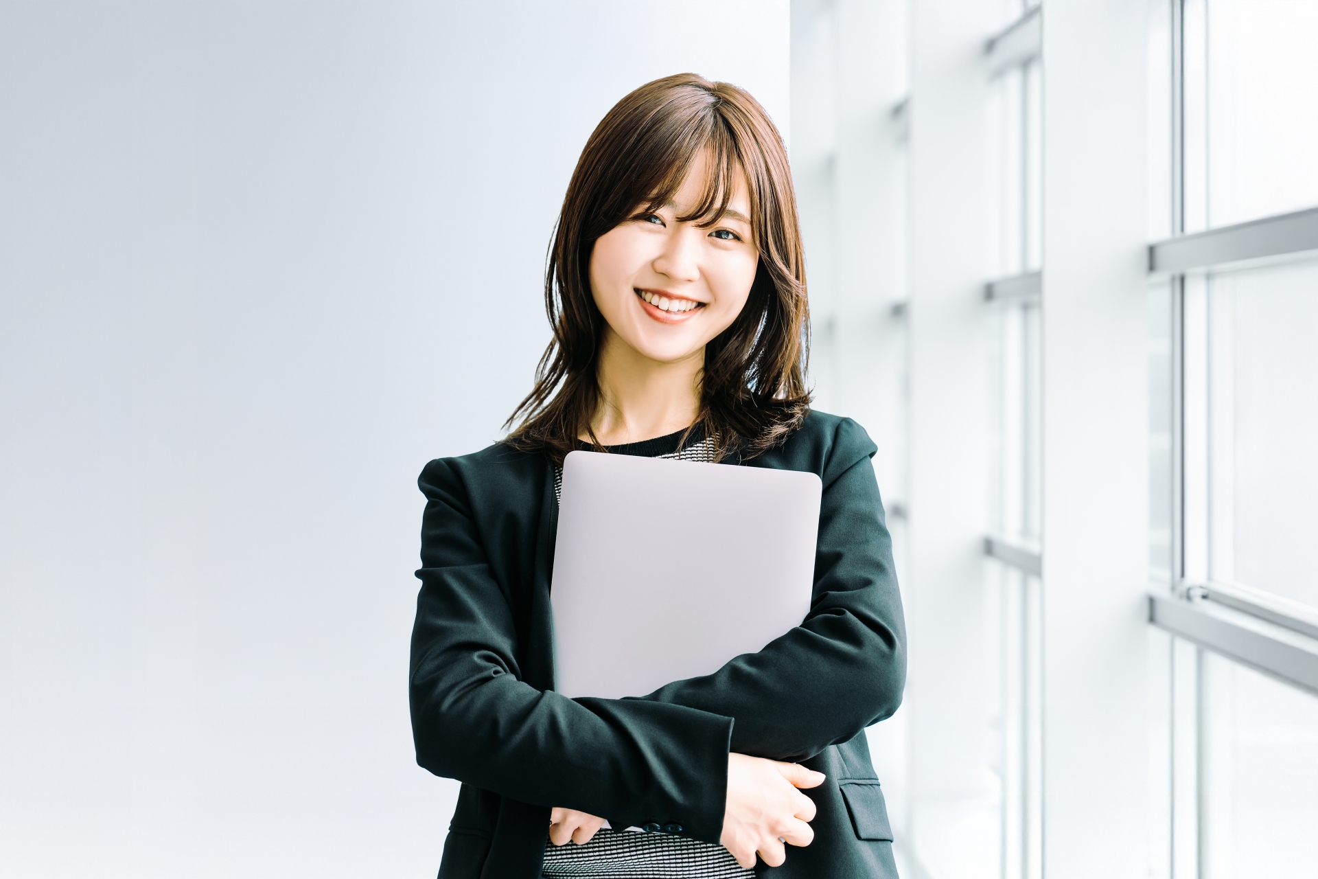 笑顔でパソコンを持つ女性